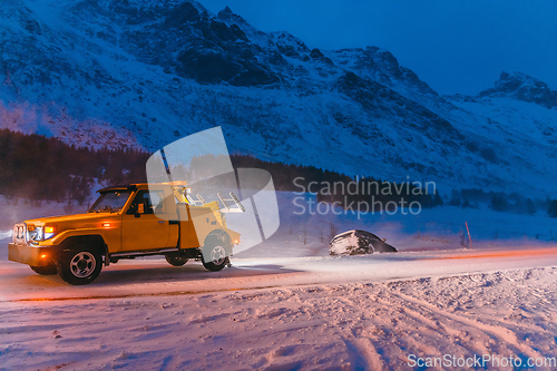 Image of The roadside assistance service pulling the car out of the canal. An incident on a frozen Scandinavian road.