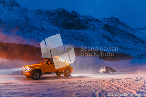 Image of The roadside assistance service pulling the car out of the canal. An incident on a frozen Scandinavian road.