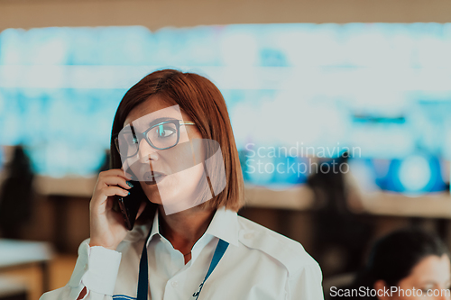 Image of Female security operator working in a data system control room offices Technical Operator Working at workstation with multiple displays, security guard working on multiple monitors