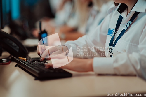 Image of Group of Security data center operators working in a CCTV monitoring room looking on multiple monitors.Officers Monitoring Multiple Screens for Suspicious Activities