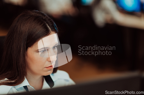 Image of Female security operator working in a data system control room offices Technical Operator Working at workstation with multiple displays, security guard working on multiple monitors