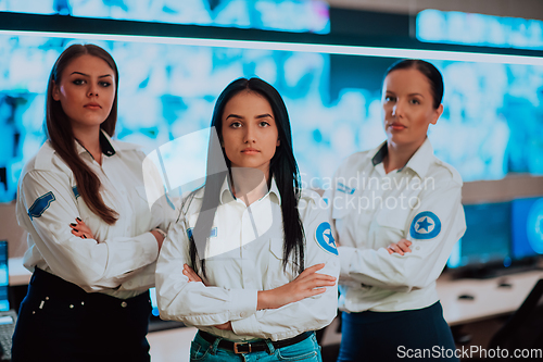 Image of Group portrait of female security operator while working in a data system control room offices Technical Operator Working at workstation with multiple displays, security guard working on multiple