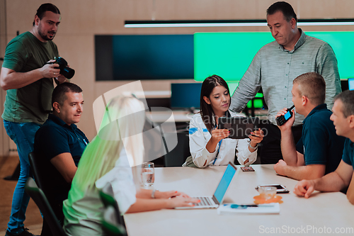 Image of Group of security guards sitting and having briefing In the system control room They're working in security data center surrounded by multiple Screens