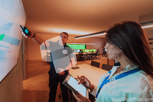 Image of Group of security operators working in a data system control room Technical Operators Working at workstation with multiple displays, security guards working on multiple monitors in surveillan