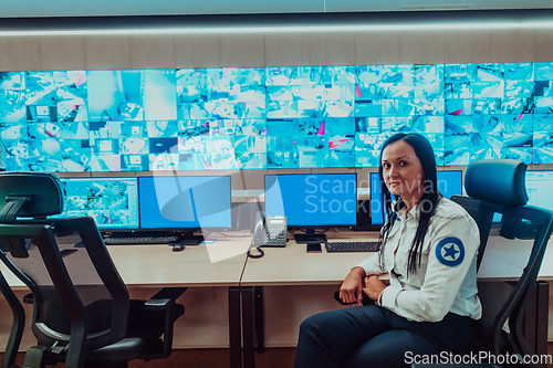 Image of Female security operator working in a data system control room offices Technical Operator Working at workstation with multiple displays, security guard working on multiple monitors