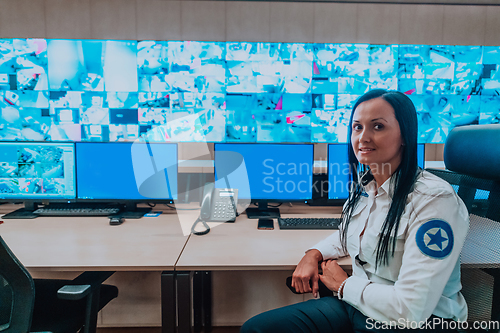 Image of Female security operator working in a data system control room offices Technical Operator Working at workstation with multiple displays, security guard working on multiple monitors