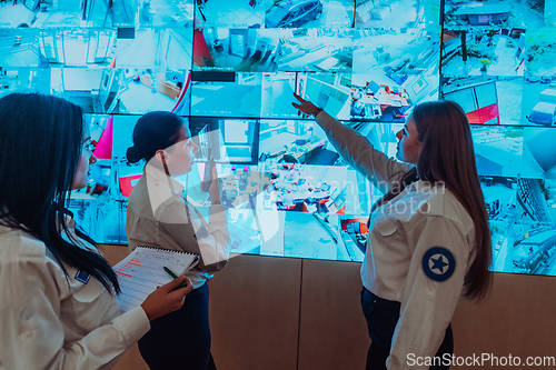 Image of Group portrait of female security operator while working in a data system control room offices Technical Operator Working at workstation with multiple displays