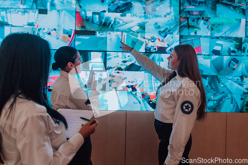 Image of Group portrait of female security operator while working in a data system control room offices Technical Operator Working at workstation with multiple displays