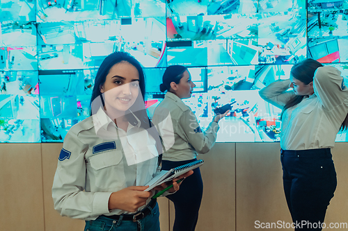 Image of Group portrait of female security operator while working in a data system control room offices Technical Operator Working at workstation with multiple displays