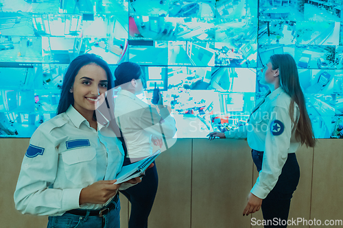 Image of Group portrait of female security operator while working in a data system control room offices Technical Operator Working at workstation with multiple displays