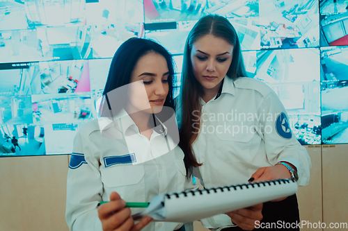 Image of Group portrait of female security operator while working in a data system control room offices Technical Operator Working at workstation with multiple displays