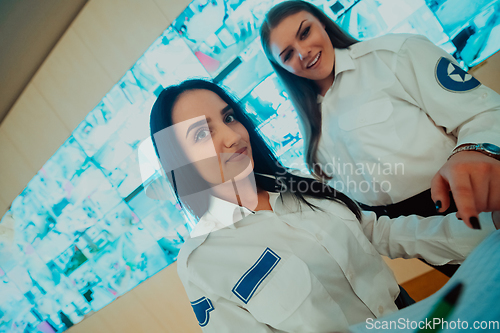 Image of Group portrait of female security operator while working in a data system control room offices Technical Operator Working at workstation with multiple displays