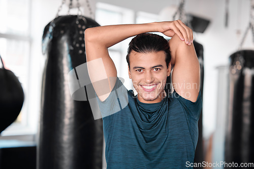 Image of Portrait, stretching arm and man in gym ready to start workout, training or exercise. Sports smile, health fitness and happy male athlete warm up, stretch or prepare for exercising for flexibility.