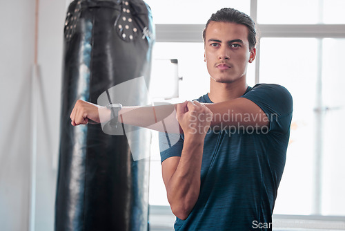 Image of Serious, stretching arm and man in gym ready to start workout, training or exercise. Sports fitness, thinking and young male athlete warm up, stretch arms or prepare for exercising for flexibility.