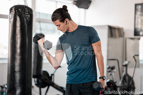 Image of Exercise, dumbbell and man with earphones in gym for streaming music while exercising. Sports workout, fitness and bodybuilder listen to podcast or radio while lifting weights for strength training.