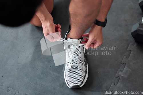 Image of Top view, hands and tie shoes in gym to start workout, training or exercise for sports. Athlete, man and tying laces on sneakers to prepare for running, cardio or exercising for health or fitness.