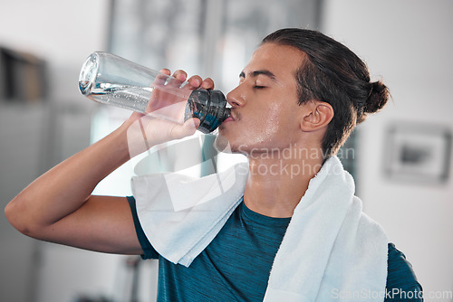 Image of Fitness, man and drinking water for hydration after workout, exercise or intense training at home. Thirsty male resting from sports exercising for hydrated wellness, health and fresh natural drink