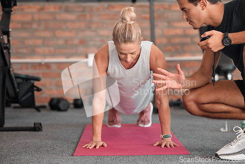 Image of Fitness, push up and people, personal trainer or woman in gym coaching for support, performance check and muscle goals. Athlete, sports person in strong workout, exercise motivation or training timer