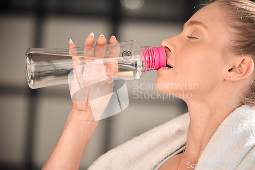 Image of Fitness, athlete and woman drinking water in gym after workout, training or exercise. Sports, nutrition and thirsty athletic female drink liquid aqua from bottle for hydration, health and wellness