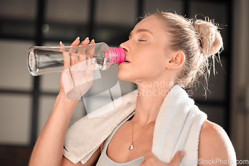 Image of Athlete, fitness and woman drinking water in gym after workout, training or exercise. Sports, nutrition and thirsty athletic female drink liquid aqua from bottle for hydration, health and wellness.