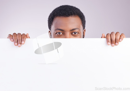 Image of Mockup, space and portrait of a black man with a board isolated on a white background in a studio. Showing, branding and an African person peaking from a blank poster with mock up for advertisement