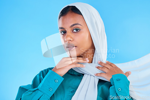 Image of Woman, muslim and portrait of hijab in studio, blue background or color backdrop. Young female model, islamic culture or scarf for peace, religion and arabic fashion of eid mubarak, beauty or ramadan