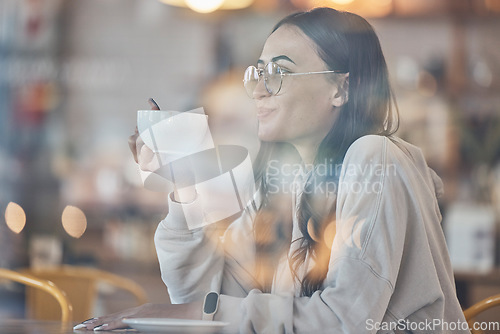 Image of Thinking, smile and a woman drinking coffee in a cafe to relax alone over the weekend behind glass. Idea, happy and caffeine with an attractive young female enjoying a beverage in a restaurant