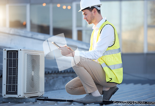 Image of Man, engineer and tablet on roof for air conditioning maintenance, tech and digital analysis. Technician, mobile touchscreen and rooftop for ac repair for building, industry and development in city