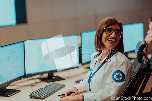 Image of Female security operator working in a data system control room offices Technical Operator Working at workstation with multiple displays, security guard working on multiple monitors