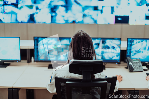 Image of Female security operator working in a data system control room offices Technical Operator Working at workstation with multiple displays, security guard working on multiple monitors