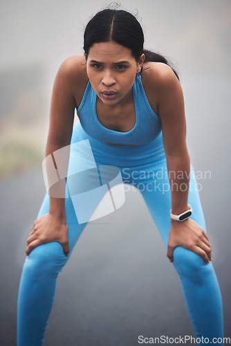 Image of Tired, fitness and breathing woman for outdoor cardio training, workout and sports running break in mist or fog. Focus, thinking and serious runner person with exercise goals and challenge in street