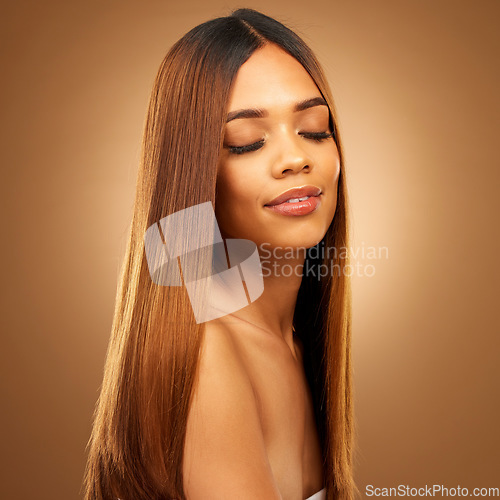 Image of Beauty, hair care and face of woman in studio for growth and color shine or healthy texture. Aesthetic female model for haircare, natural makeup glow and hairdresser or salon on a brown background