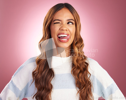 Image of Funny, face and goofy woman tongue out feeling happy, playful and excited isolated in a studio purple background. Comic, joke and head of a young and crazy female wink for humor or happiness