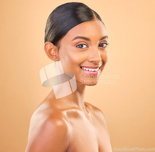 Image of Smile, glowing and portrait skincare of a woman isolated on a studio background. Happy, beautiful and an Indian model with a glow from cosmetics, healthy skin and smooth complexion on a backdrop