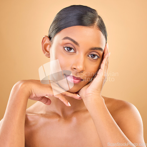 Image of Face portrait, skincare and beauty of woman in studio isolated on brown background. Makeup, serious cosmetics and confident Indian female model with spa facial treatment for healthy or flawless skin.