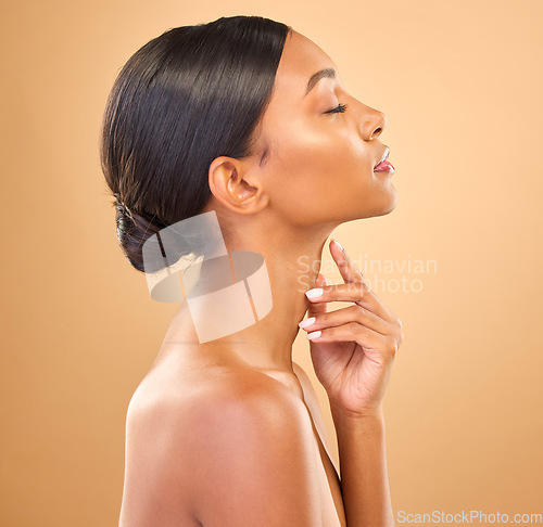Image of Face, beauty and skincare profile of woman in studio for cosmetics, dermatology or makeup. Aesthetic female .hand on skin for self care, natural glow or spa facial shine results on a brown background