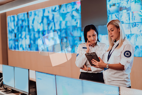 Image of Group portrait of female security operator while working in a data system control room offices Technical Operator Working at workstation with multiple displays