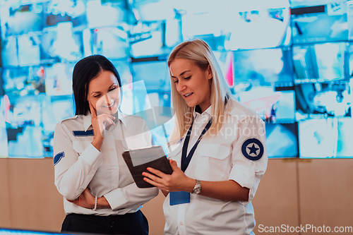 Image of Group portrait of female security operator while working in a data system control room offices Technical Operator Working at workstation with multiple displays