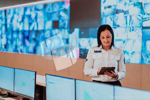 Image of Female security operator working in a data system control room offices Technical Operator Working at workstation with multiple displays, security guard working on multiple monitors