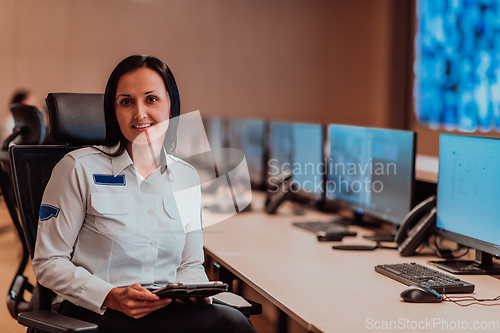 Image of Female security operator working in a data system control room offices Technical Operator Working at workstation with multiple displays, security guard working on multiple monitors