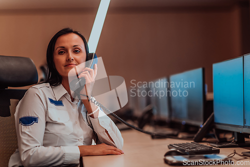 Image of Female security operator working in a data system control room offices Technical Operator Working at workstation with multiple displays, security guard working on multiple monitors