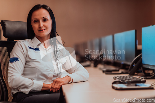 Image of Female security operator working in a data system control room offices Technical Operator Working at workstation with multiple displays, security guard working on multiple monitors