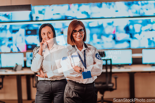 Image of Group portrait of female security operator while working in a data system control room offices Technical Operator Working at workstation with multiple displays