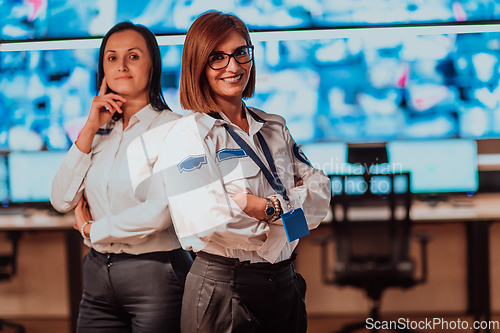 Image of Group portrait of female security operator while working in a data system control room offices Technical Operator Working at workstation with multiple displays