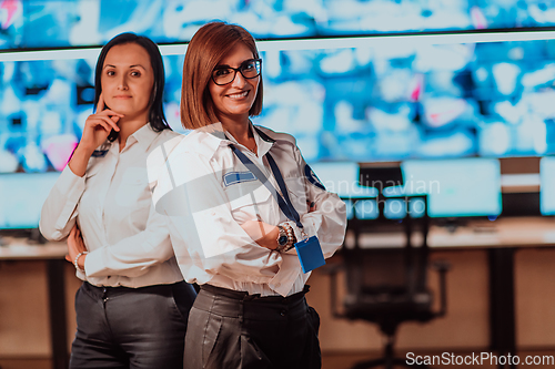 Image of Group portrait of female security operator while working in a data system control room offices Technical Operator Working at workstation with multiple displays