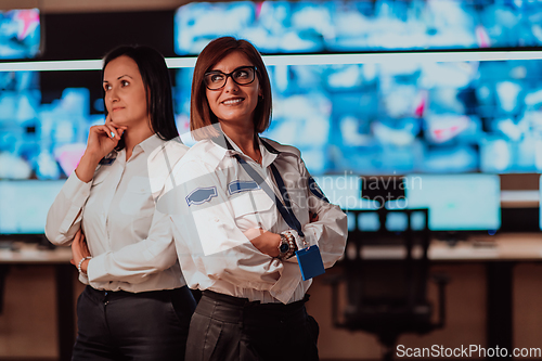 Image of Group portrait of female security operator while working in a data system control room offices Technical Operator Working at workstation with multiple displays