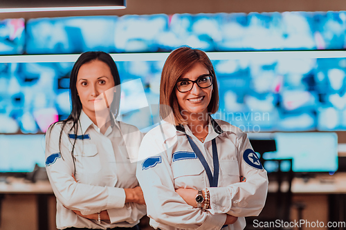 Image of Group portrait of female security operator while working in a data system control room offices Technical Operator Working at workstation with multiple displays