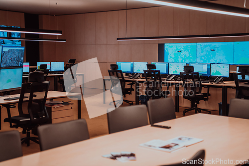 Image of Empty interior of big modern security system control room, workstation with multiple displays, monitoring room with at security data center Empty office, desk, and chairs at a main CCTV security data