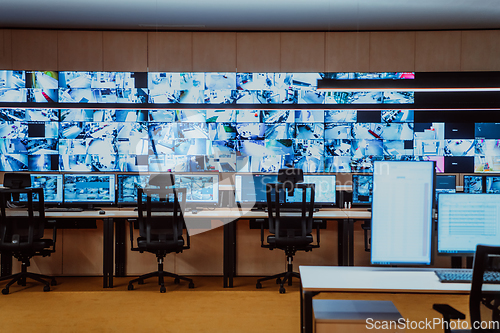 Image of Empty interior of big modern security system control room, workstation with multiple displays, monitoring room with at security data center Empty office, desk, and chairs at a main CCTV security data