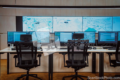 Image of Empty interior of big modern security system control room, workstation with multiple displays, monitoring room with at security data center Empty office, desk, and chairs at a main CCTV security data
